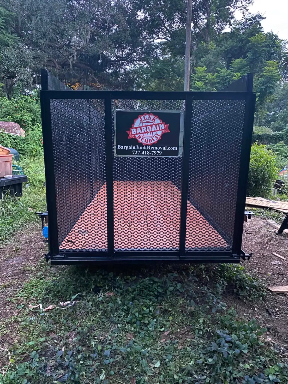Bargain Junk Removal 12-yard dumpster trailer with high mesh walls and loading ramp.